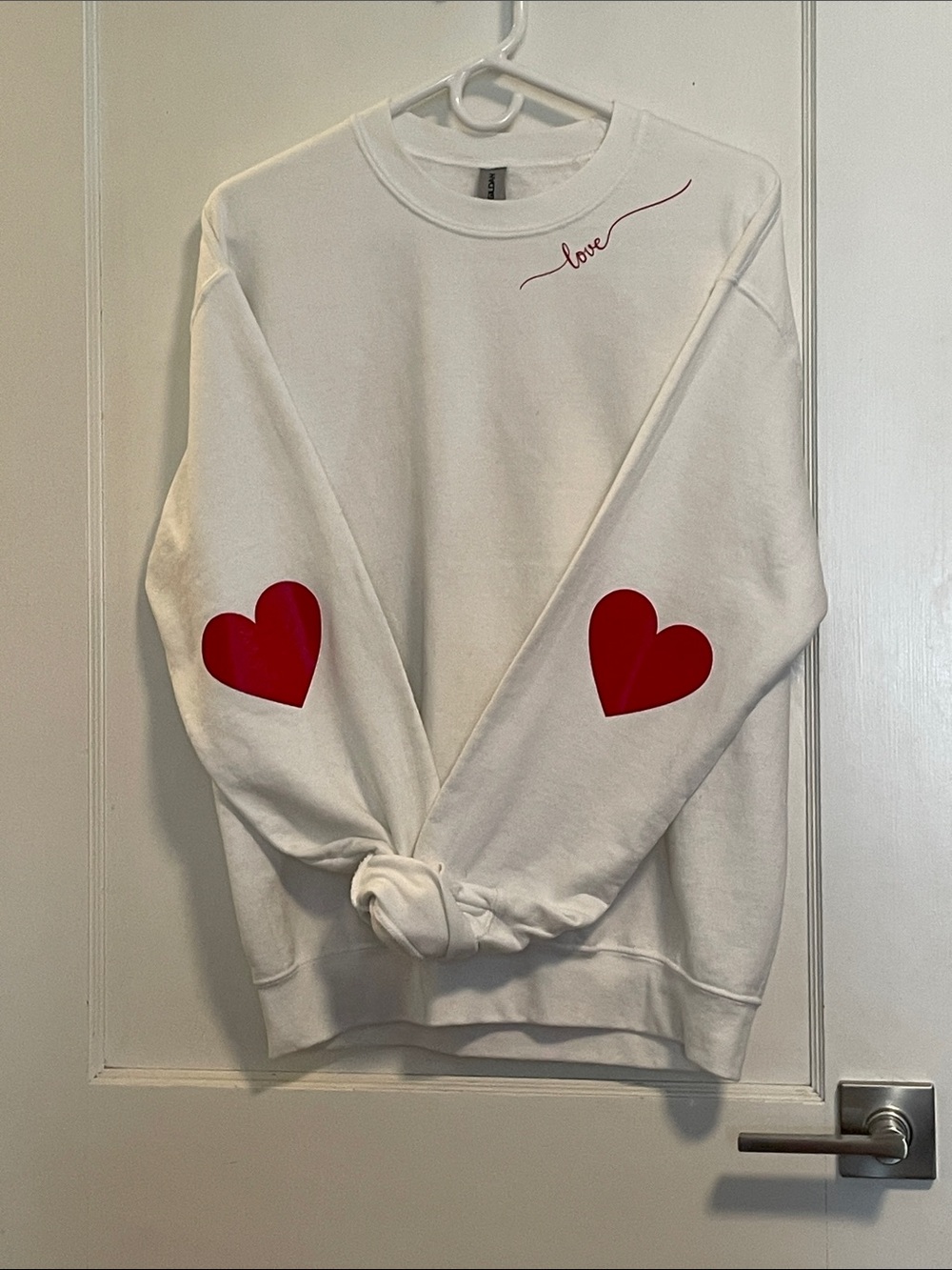 White “love” sweatshirt with hearts on the elbows